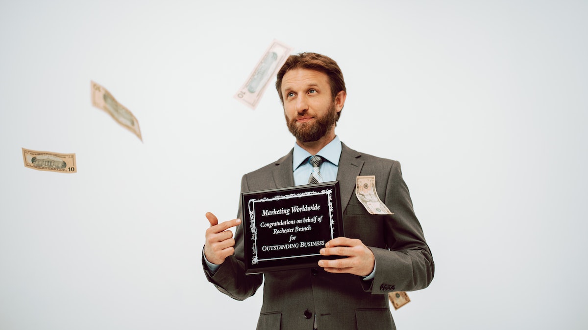 A man in a business suit holding a black plaque.