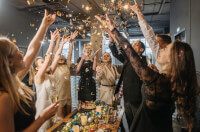Group of people tossing confetti during a corporate party.
