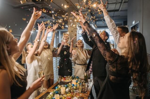 Group of people tossing confetti during a corporate party.