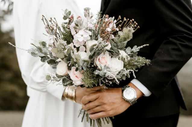 Wedding couple holding a bucket together.