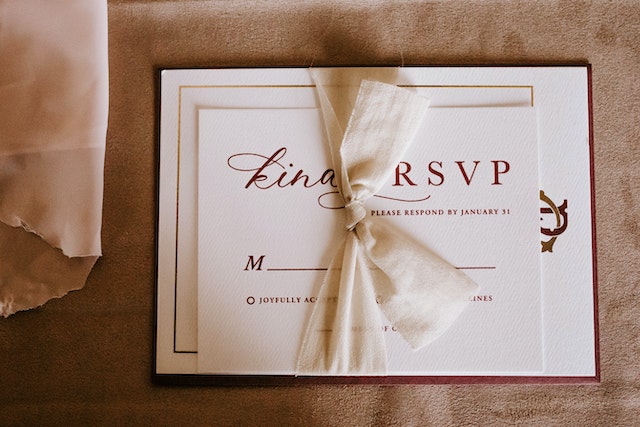 A beautiful RSVP card with a bow as an essential of every event party checklist.