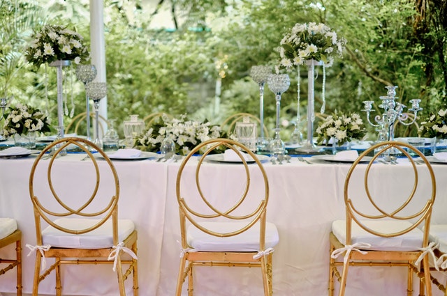 Three yellow padded chairs beside a table